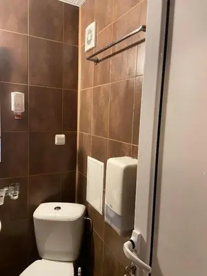 a bathroom with a white toilet in a stall at Хотел ЮГ in Primorsko