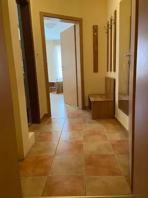 a hallway with a tiled floor in a house at Хотел ЮГ in Primorsko