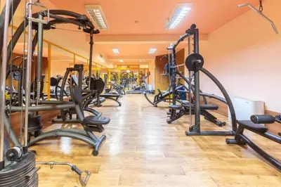 a gym with several treadmills and exercise bikes at Хотел ЮГ in Primorsko