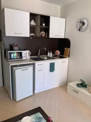 a kitchen with white cabinets and a sink and a microwave at Apartment Nani -Sunny beach in Sunny Beach