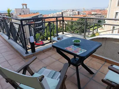 a table and chairs on a balcony with a view at Rooftop Sea View Apartment Sveti Vlas in Sveti Vlas