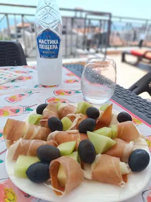 a plate of food on a table with a bottle of water at Rooftop Sea View Apartment Sveti Vlas in Sveti Vlas