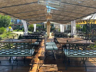 a group of tables and chairs under a pavilion at Hotel Surf Primorsko in Primorsko