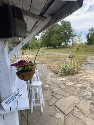 a porch with two white stools and a flower pot at Hotel Surf Primorsko in Primorsko