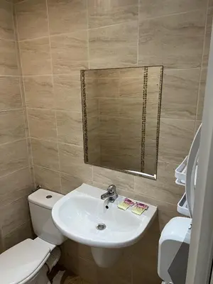 a bathroom with a sink and a toilet and a mirror at Hotel Surf Primorsko in Primorsko