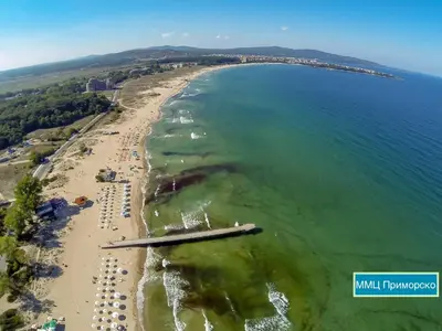 an aerial view of a beach with chairs and the ocean at Hotel Surf Primorsko in Primorsko