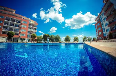a large swimming pool with blue water and buildings at Paradise View in Sunny Beach