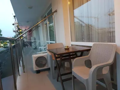 a balcony with a wooden table and chairs and a window at Cozy apartment by Julie in Sunny Beach