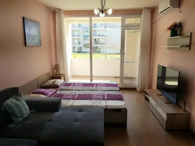 a living room with a couch and a large window at Sarafovo Sea Paradise in Burgas City