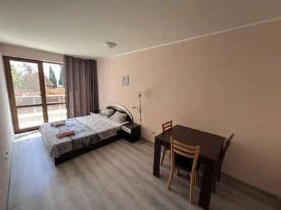 a bedroom with a bed and a table and a window at Vadim Apartments in Panorama Beach Vigo Nessebar in Nesebar
