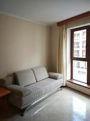 a couch in the corner of a room with a window at Vadim Apartments in Panorama Beach Vigo Nessebar in Nesebar