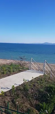 a boardwalk leading to the ocean on a beach at Сарафово Лукс Тераса Първа Линия in Sarafovo