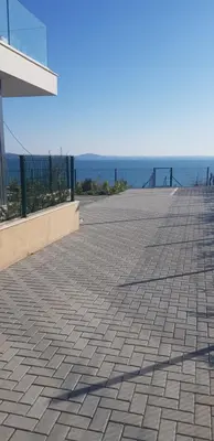 a brick sidewalk with the ocean in the background at Сарафово Лукс Тераса Първа Линия in Sarafovo