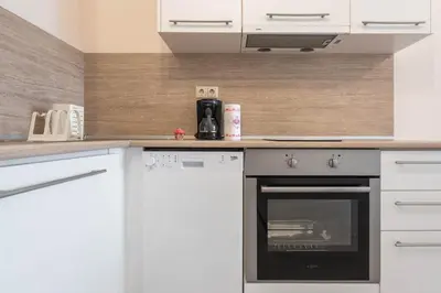 a kitchen with white cabinets and an oven at Seaside Apartment in Varna City
