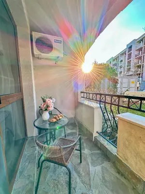 a table and chair on a balcony with a view at Студио Каскадас М5 in Sunny Beach
