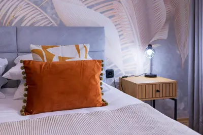 a bedroom with a bed with a orange pillow on it at The Cozy Hub, Varna in Varna City