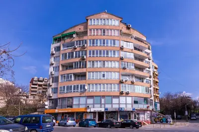a tall building with cars parked in front of it at The Cozy Hub, Varna in Varna City