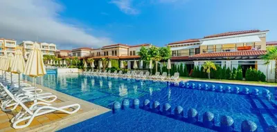 a large swimming pool with chairs and umbrellas at Ваканционна Къща в Greenn Life Созопол in Sozopol