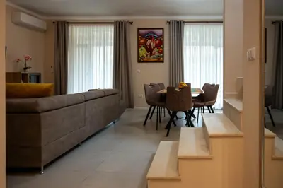 a living room with a couch and a table and chairs at Ваканционна Къща в Greenn Life Созопол in Sozopol