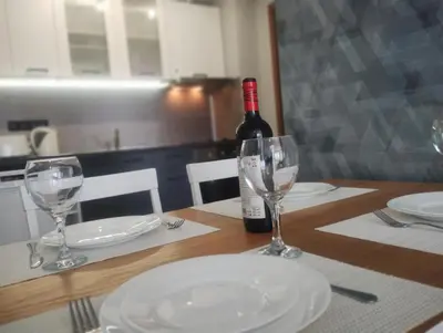a bottle of wine sitting on a table with glasses at Apartament Prestige Fort - Bastet BS in Sveti Vlas