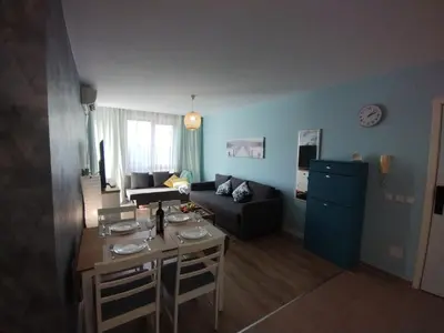 a living room with a table and a couch at Apartament Prestige Fort - Bastet BS in Sveti Vlas