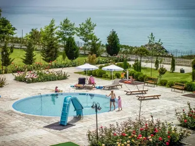 a pool with a slide and people standing around it at Apartament Prestige Fort - Bastet BS in Sveti Vlas