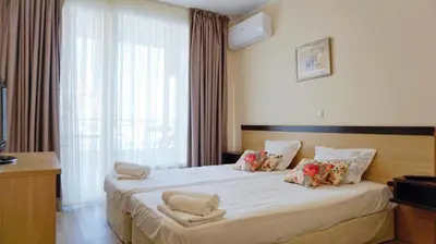 a hotel room with a large bed with flowers on it at Apartments Obzor Beach B - Апартаменти Обзор Бийч B in Obzor
