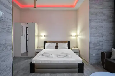 a bedroom with a large white bed and a couch at Studio in Sarafovo with Private Parking Spot by Flat Mаnаger in Burgas City