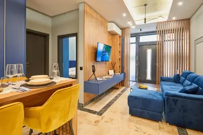 a living room with a blue couch and a table at Florance Rentals Luxury Apartments in Burgas in Burgas City