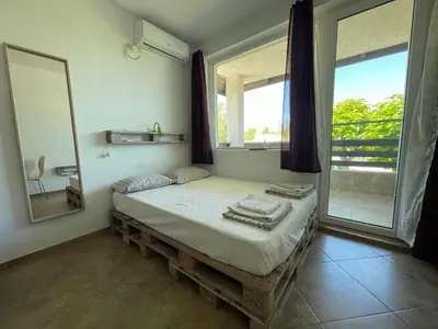 a bedroom with a bed with a mirror and a window at Caprice Apartment in Lozenec in Kiten