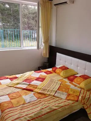 a bedroom with a bed with a quilt and a window at Caprice Apartment in Lozenec in Kiten