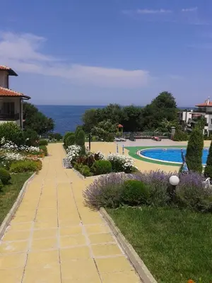 a garden with a walkway and a swimming pool at Caprice Apartment in Lozenec in Kiten