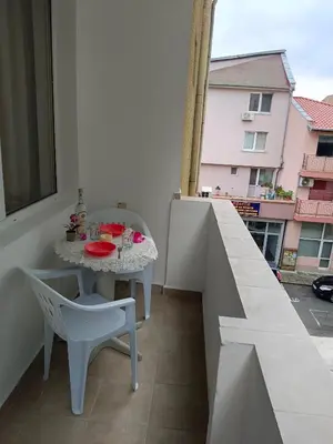 a small white table and chairs on a balcony at Стаи за гости Ники in Nesebar