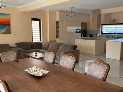 a living room with a wooden table and a kitchen at Luxury Sea Villas - Kabalan in Burgas City