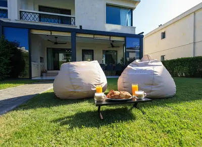 two bean bags with a plate of food in the grass at Luxury Sea Villas - Kabalan in Burgas City