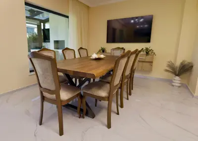 a dining room with a wooden table and chairs at Luxury Sea Villas - Kabalan in Burgas City