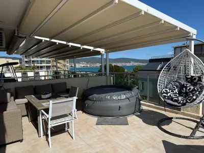 a patio with a bed and a table and a swing at YS Residence in Sunny Beach