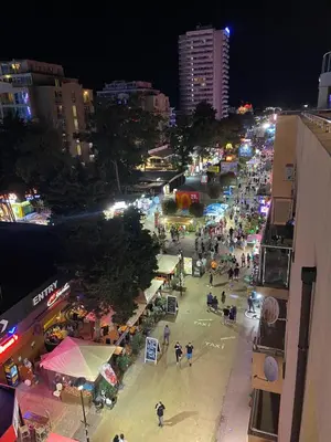 a city street at night with a crowd of people at YS Residence in Sunny Beach
