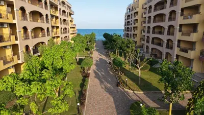 an empty street between two apartment buildings with trees at DL Apartments in Aheloy