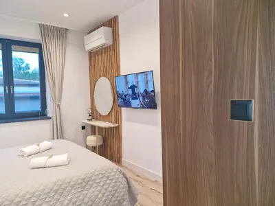 a bedroom with a bed and a tv on a wall at Apartment Marbél - Designer Retreat with FREE parking in Burgas City