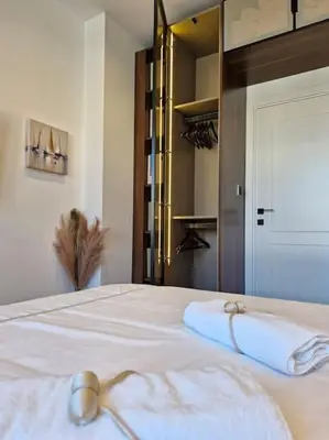 a bedroom with a bed with two towels on it at Apartment Marbél - Designer Retreat with FREE parking in Burgas City