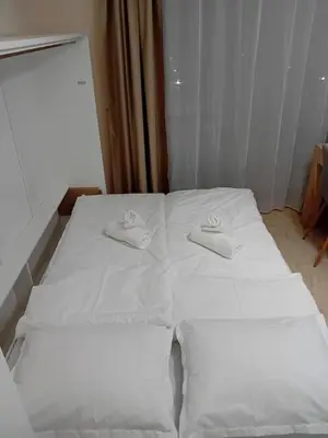 a bed with two white hats on top of it at Sveti Vlas Sea Dreams apartament in Sveti Vlas