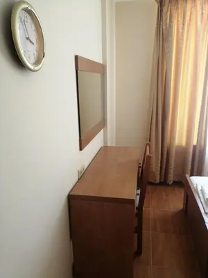 a room with a desk and a clock on the wall at Panorama Dreams - Sveti Vlas - Furnished Apartment with a Terrace and a Sea View in Sveti Vlas