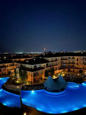 a large building with a pool at night at Panorama Dreams - Sveti Vlas - Furnished Apartment with a Terrace and a Sea View in Sveti Vlas