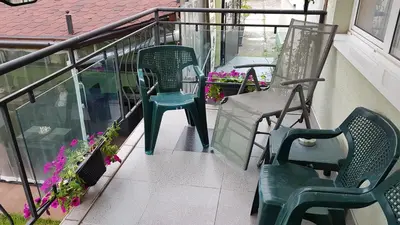 a balcony with two chairs and flowers on a porch at Aheloy Apartments in Aheloy