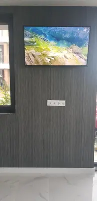 a television on a wall with a painting on it at Сарафово Лукс Гарден Първа Линия in Burgas City