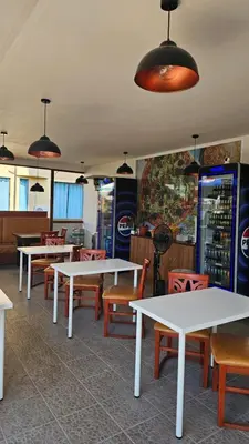 a dining room with tables and chairs and pendant lights at Three-room apartment in Sveti Vlas