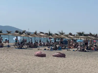 a group of people laying on the beach at SeaView Lazur Apartment in Burgas City