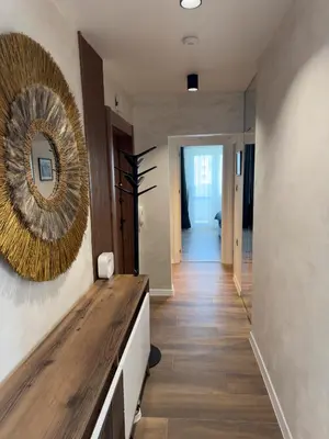 a hallway with a mirror on the wall and a wooden counter at SeaView Lazur Apartment in Burgas City