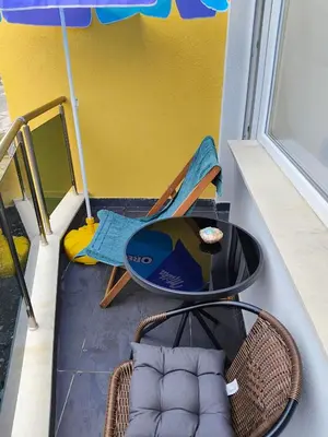 a room with a table and chairs and an umbrella at Apartment SUN RAYS Nesebar in Nesebar